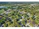 Overhead view of the community featuring mature trees, nearby schools and recreational areas, and a calm lake at 3517 Merivale Dr, Casselberry, FL 32707