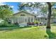 Wide shot of backyard featuring a sunroom, a well-maintained lawn, and mature trees at 3517 Merivale Dr, Casselberry, FL 32707