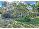 View of the house from the backyard, featuring a sunroom and a beautifully landscaped yard at 3517 Merivale Dr, Casselberry, FL 32707