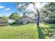 Exterior view of a sunroom from the backyard with a well-maintained lawn and mature trees at 3517 Merivale Dr, Casselberry, FL 32707