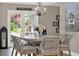 Dining room features French doors, unique chandelier, seating for six, and artwork on the wall at 3517 Merivale Dr, Casselberry, FL 32707
