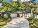 View of a home with a driveway, a two-car garage and a beautiful green lawn at 3517 Merivale Dr, Casselberry, FL 32707