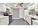 Clean kitchen with white cabinets, stainless steel appliances and gray tile flooring at 3517 Merivale Dr, Casselberry, FL 32707