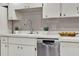 Bright kitchen features stainless steel dishwasher, stainless steel faucet, white countertops, and white cabinets at 3517 Merivale Dr, Casselberry, FL 32707