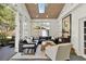 Bright sunroom with large windows, wood ceiling, comfortable seating, and access to the backyard at 3517 Merivale Dr, Casselberry, FL 32707