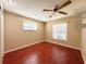 Cozy bedroom with two windows, rich flooring, and a ceiling fan at 361 Tulip Trl, Casselberry, FL 32707