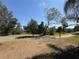 Expansive yard with mature trees and an access road, providing a serene and natural setting at 361 Tulip Trl, Casselberry, FL 32707