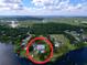 Stunning aerial view of a lakeside home with a charming lighthouse and abundant trees, offering a serene retreat at 407 Sheryl Dr, Deltona, FL 32738