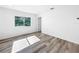 Bright bedroom featuring a large window, gray hardwood floors, and fresh white paint at 407 Sheryl Dr, Deltona, FL 32738