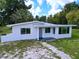 Charming single-story home featuring a modern exterior design with well maintained grass and landscaping at 407 Sheryl Dr, Deltona, FL 32738
