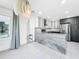Modern open kitchen with gray and white cabinets, stylish countertops, and stainless-steel appliances, with a view to the dining area at 407 Sheryl Dr, Deltona, FL 32738