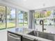 Kitchen featuring stainless appliances, granite countertops, a modern sink, and views of the outdoor landscaping at 407 Sheryl Dr, Deltona, FL 32738