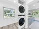 Stacked washer and dryer units are conveniently located near a window with views of the lake at 407 Sheryl Dr, Deltona, FL 32738