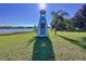 A whimsical lighthouse feature adds charm to this waterfront property with beautiful lake views on a clear sunny day at 407 Sheryl Dr, Deltona, FL 32738