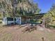 Outbuilding with an awning is nestled among trees, offering additional storage at 407 Sheryl Dr, Deltona, FL 32738