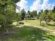 View of the expansive green lawn and driveway leading to the property, with mature trees providing shade and privacy at 407 Sheryl Dr, Deltona, FL 32738
