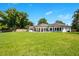 Lush green backyard featuring the home's exterior and large lawn area perfect for outdoor activities at 4210 Waterfront Pkwy, Orlando, FL 32806