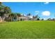 Expansive backyard with lush green lawn, white home exterior, and mature palm trees at 4210 Waterfront Pkwy, Orlando, FL 32806