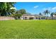 Wide shot of the backyard showcasing the green lawn, white home exterior, and beautiful landscaping at 4210 Waterfront Pkwy, Orlando, FL 32806