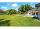 Backyard view with a well-maintained lawn, swimming pool, lake, and a covered outdoor seating area at 4210 Waterfront Pkwy, Orlando, FL 32806
