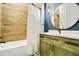 Stylish bathroom with wood-look tile walls, a modern vanity, a unique round mirror, and decorative lighting at 4210 Waterfront Pkwy, Orlando, FL 32806