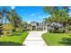 Beautiful home with a lush green lawn, towering palm trees, and a curved driveway at 4210 Waterfront Pkwy, Orlando, FL 32806