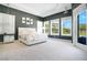 Spacious main bedroom featuring a luxurious white bed set, tray ceilings, and scenic backyard views at 4210 Waterfront Pkwy, Orlando, FL 32806