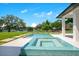 Outdoor pool and spa with lush green lawn and beautiful lake views on a bright sunny day at 4210 Waterfront Pkwy, Orlando, FL 32806