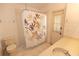 Well-lit bathroom with white fixtures and a shower-tub featuring leaf-patterned curtains at 4336 Cloverleaf Pl, Casselberry, FL 32707