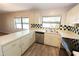 Bright kitchen featuring stainless appliances, checkerboard backsplash, and wood look tile floors at 4336 Cloverleaf Pl, Casselberry, FL 32707