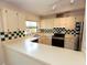 Kitchen featuring white countertops, cabinetry, checkerboard backsplash, and stainless steel appliances at 4336 Cloverleaf Pl, Casselberry, FL 32707