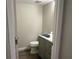 A modern half bathroom features a new toilet, vanity with sink, and a neutral color scheme at 4838 Pebble Beach Dr # A, Orlando, FL 32811