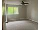 A bright bedroom featuring a ceiling fan and a large window offering green outdoor views at 4838 Pebble Beach Dr # A, Orlando, FL 32811