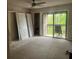 Spacious bedroom with neutral carpet, closet, and sliding glass door to balcony at 4838 Pebble Beach Dr # A, Orlando, FL 32811