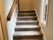 Carpeted staircase leading upstairs to the next level of the home, featuring a window and natural light at 4838 Pebble Beach Dr # A, Orlando, FL 32811