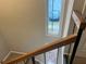 A well-lit staircase features carpeted steps and a wooden handrail, with a view of the outdoors from a window at 4838 Pebble Beach Dr # A, Orlando, FL 32811