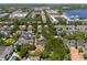 Aerial view of a residential community featuring a mix of housing, lush trees, and a glimpse of a tranquil lake at 5038 Fenwood Ln, Orlando, FL 32814
