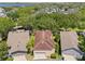 Aerial view of home with tile roof, two-car garage, landscaping, and proximity to a lake at 5038 Fenwood Ln, Orlando, FL 32814