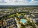 An aerial view of a residential area showcasing a community pool and park surrounded by lush trees and neighborhood at 5038 Fenwood Ln, Orlando, FL 32814