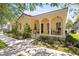 Charming home boasts a stucco facade, arched porch, and mature landscaping at 5038 Fenwood Ln, Orlando, FL 32814