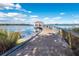 Scenic view of a wooden pier extending into a calm lake, complete with a gazebo and benches on a bright day at 5038 Fenwood Ln, Orlando, FL 32814