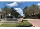 Street view of a commercial and residential community with palm trees lining the street and a fountain in the foreground at 5038 Fenwood Ln, Orlando, FL 32814