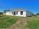 This home's backyard features an expansive lawn and a modern stucco exterior at 506 Peace Way, Kissimmee, FL 34759