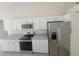 Modern kitchen with granite countertops, stainless steel appliances and white cabinetry at 506 Peace Way, Kissimmee, FL 34759
