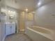 This spacious bathroom features a glass shower, large soaking tub, and vanity with ample lighting at 506 Peace Way, Kissimmee, FL 34759