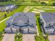 An aerial view captures modern townhomes situated next to a golf course with meticulously manicured lawns and sand traps at 507 Ocean Course Ave # 507, Davenport, FL 33896