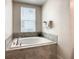 Bright bathroom featuring a tiled tub, towels and natural light from the window at 507 Ocean Course Ave # 507, Davenport, FL 33896