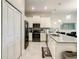 A bright kitchen featuring white cabinets, stainless steel appliances, and a stylish island with pendant lighting at 507 Ocean Course Ave # 507, Davenport, FL 33896