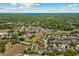An aerial shot pinpoints the home's location within a lush neighborhood, with a beautiful lake view in the distance at 528 Seven Oaks Blvd, Winter Springs, FL 32708