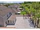 Aerial view of a home's large paver patio with a pergola, fire pit, and well-manicured landscaping at 528 Seven Oaks Blvd, Winter Springs, FL 32708